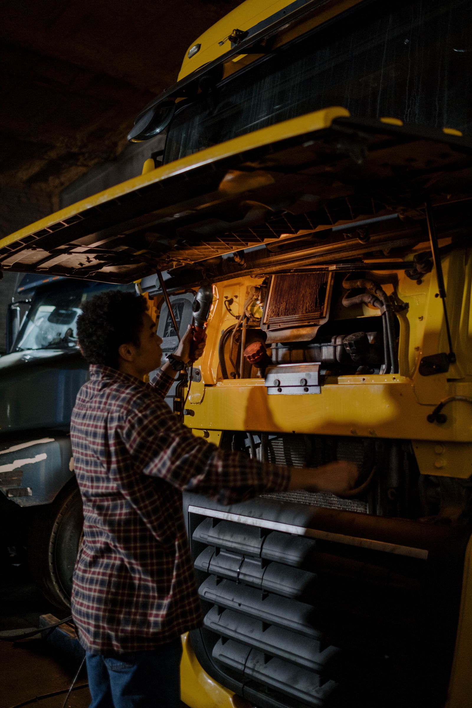 Commercial truck mechanic inspecting a heavy truck engine
